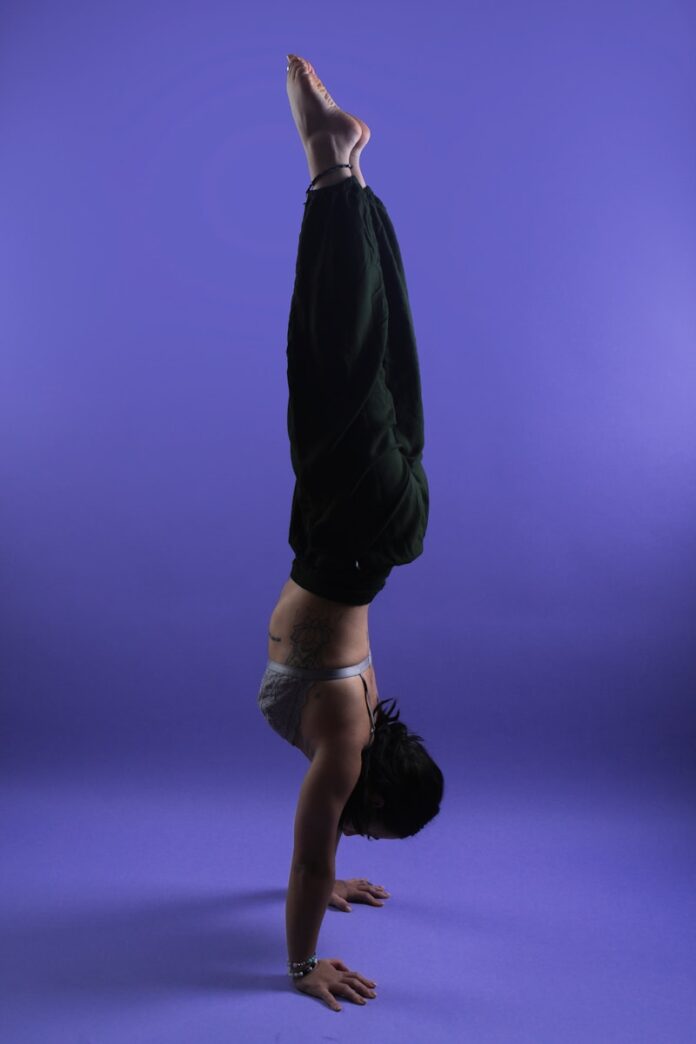 Photo by Brian Lawson a person doing a handstand on a purple background