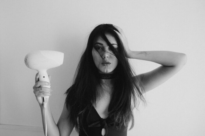 Photo by Arun Sharma woman in black tank top holding her hair