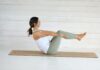 “필라테스, 현대인의 일상에 녹아드는 건강 트렌드” Woman in boat pose on yoga mat